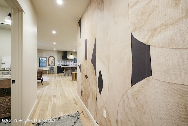 hall featuring hardwood / wood-style floors and sink