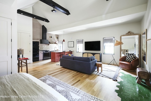 living room featuring sink, high vaulted ceiling, light wood-type flooring, and beam ceiling