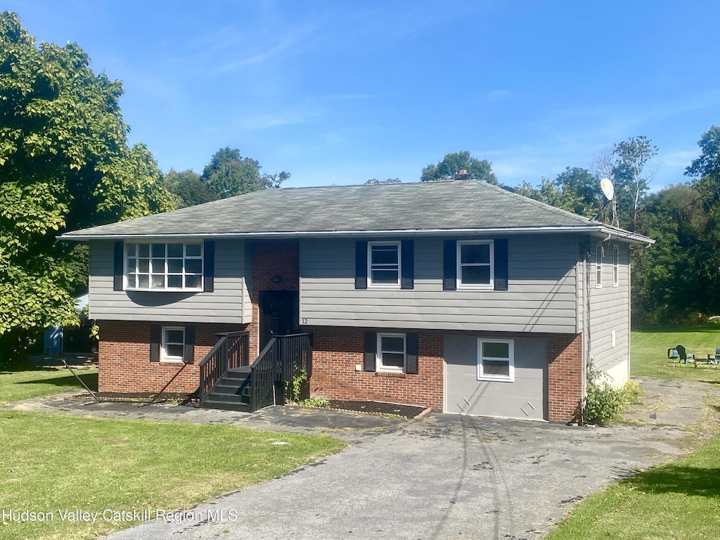 split foyer home featuring a front lawn and a garage