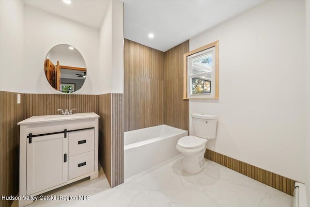 bathroom with vanity, a bathtub, toilet, and baseboard heating