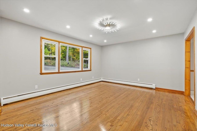 unfurnished room with light hardwood / wood-style floors and baseboard heating