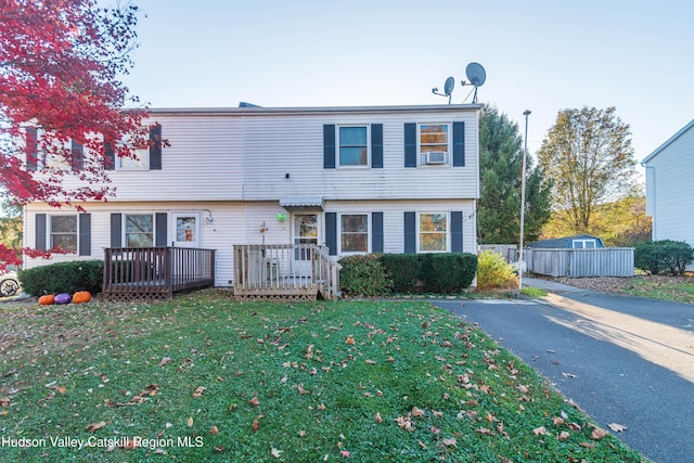 view of property with a wooden deck and a front lawn