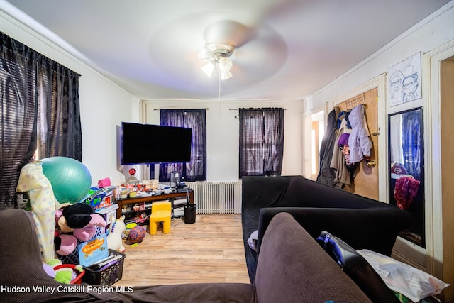 living area featuring radiator heating unit, ceiling fan, and wood finished floors