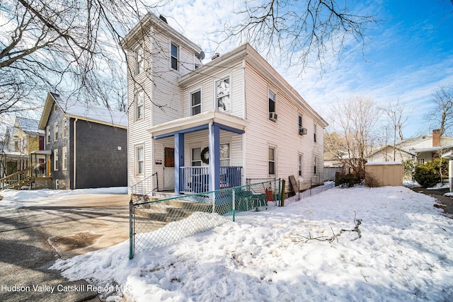 view of front facade featuring covered porch and a fenced front yard