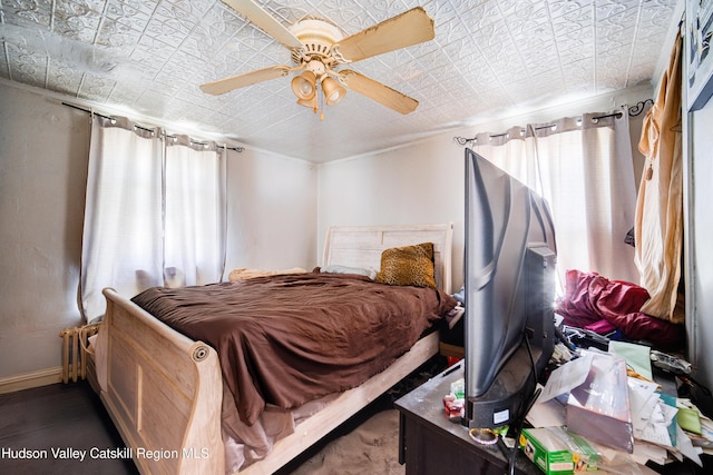 bedroom with an ornate ceiling, ceiling fan, and baseboards