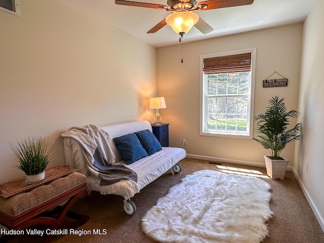 living area featuring carpet floors, a ceiling fan, baseboards, and visible vents