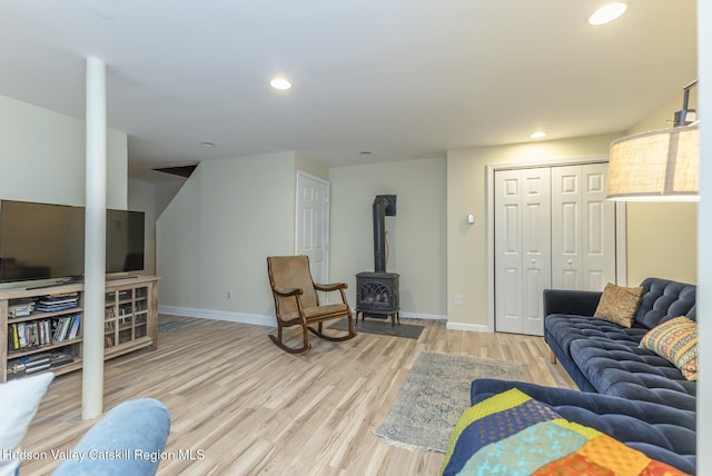 living room featuring a wood stove and light hardwood / wood-style flooring