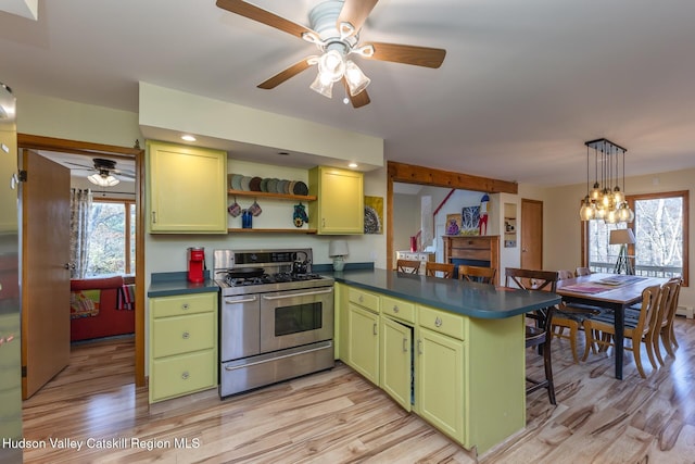 kitchen with green cabinetry, kitchen peninsula, a breakfast bar area, stainless steel stove, and light wood-type flooring