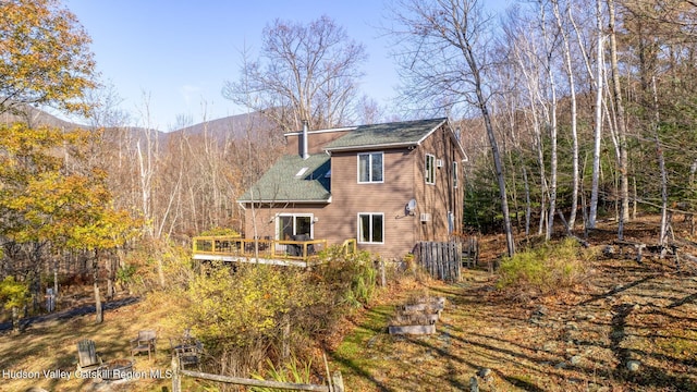 rear view of house with a deck with mountain view