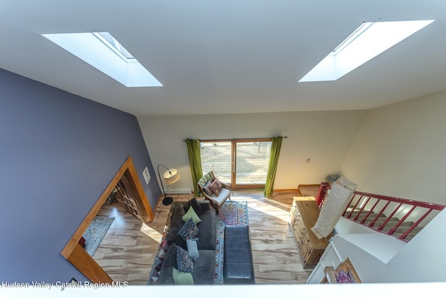 living room featuring a skylight and light hardwood / wood-style flooring