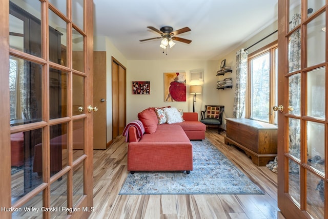 living area featuring ceiling fan, light hardwood / wood-style floors, and french doors