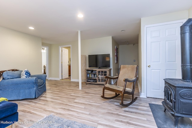 living room featuring light wood-type flooring and a wood stove