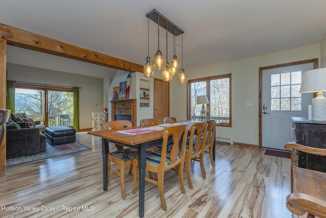 dining space featuring plenty of natural light, baseboard heating, and light hardwood / wood-style flooring