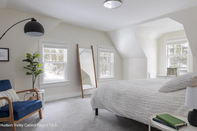 carpeted bedroom with lofted ceiling and multiple windows