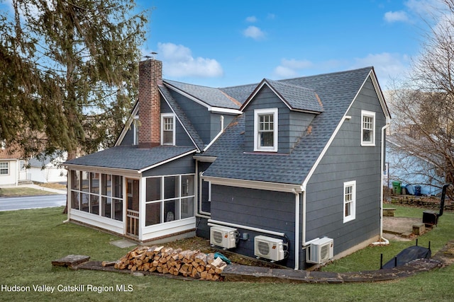 back of property with ac unit, a yard, and a sunroom