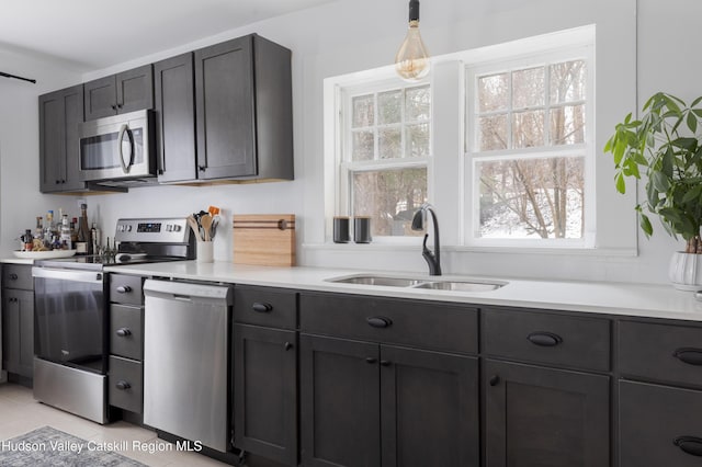 kitchen with stainless steel appliances, sink, plenty of natural light, and hanging light fixtures