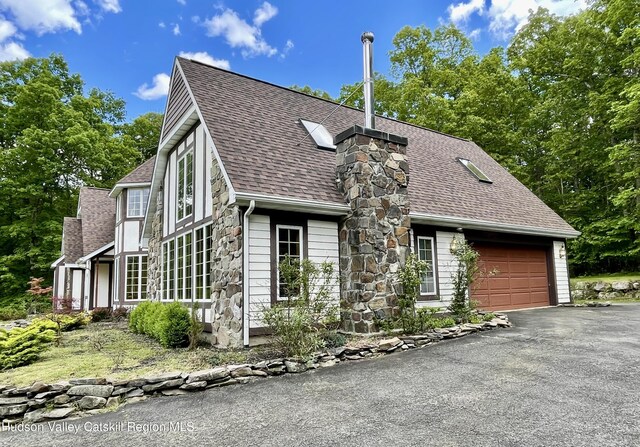 71 Saddleback Ridge Rd, Shawangunk, NY 12589 - english style home with roof with shingles, a garage, asphalt driveway, stone siding, and a chimney