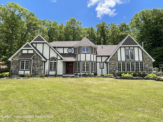 71 Saddleback Ridge Rd, Shawangunk, NY 12589 - tudor-style house with stone siding, stucco siding, a front yard, and a shingled roof