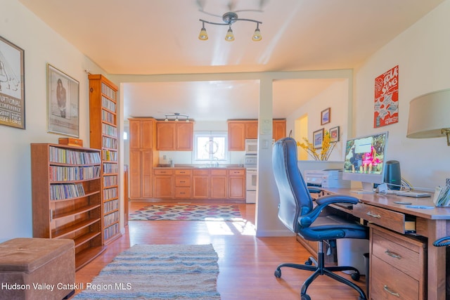 office area with light wood-style flooring and a sink