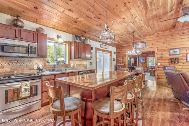 1063 Ferris Hill Rd, Roxbury, NY 12474 - kitchen featuring appliances with stainless steel finishes, open floor plan, light wood finished floors, a chandelier, and a kitchen bar