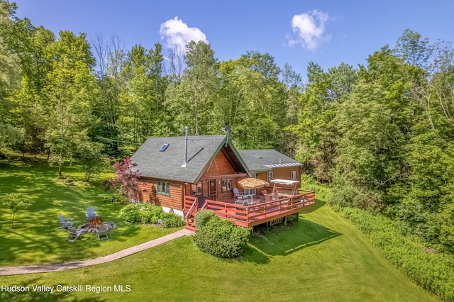 1063 Ferris Hill Rd, Roxbury, NY 12474 - rear view of house featuring an outdoor fire pit, a wooden deck, a yard, a shingled roof, and a forest view