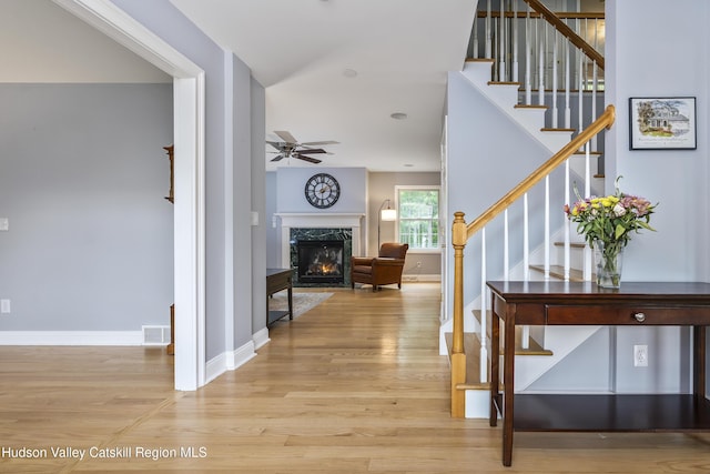 16 Shinnecock Hills Dr, Colonie, NY 12205 - foyer featuring light wood-style floors, a ceiling fan, stairs, a fireplace, and baseboards