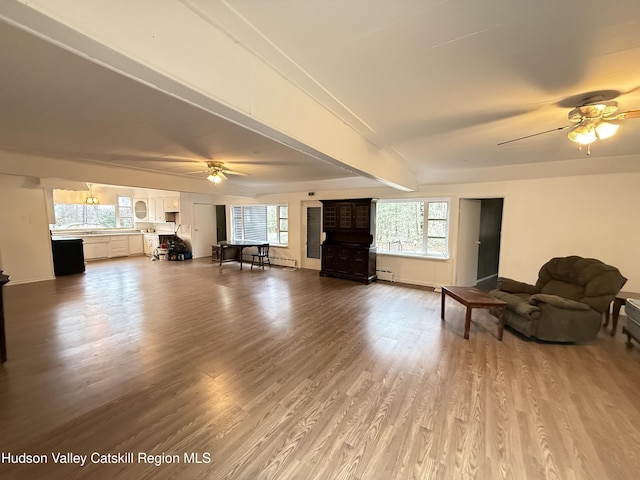 living area featuring baseboards, wood finished floors, a baseboard radiator, and ceiling fan