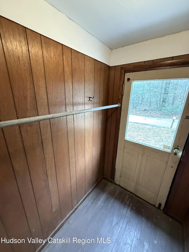 entryway with wood walls and dark wood-type flooring