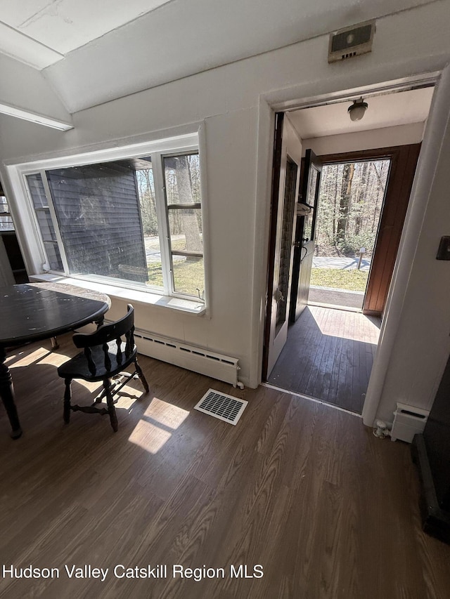 foyer with vaulted ceiling, a baseboard radiator, visible vents, and dark wood finished floors