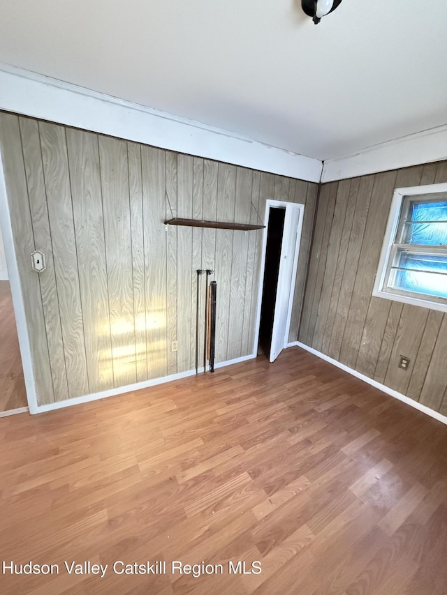 unfurnished bedroom featuring wood-type flooring and wood walls