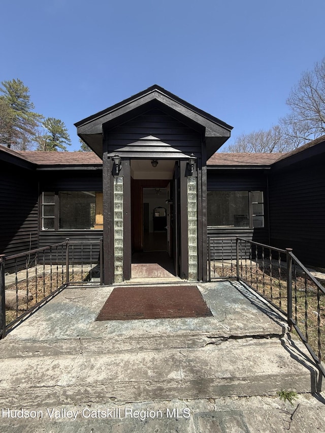 entrance to property with a shingled roof