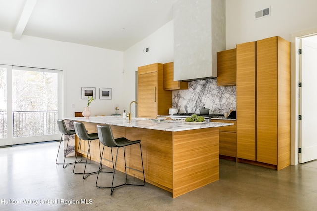 120 Old Quarry Rd, Catskill, NY 12414 - kitchen featuring a high ceiling, concrete flooring, brown cabinets, tasteful backsplash, and a kitchen breakfast bar