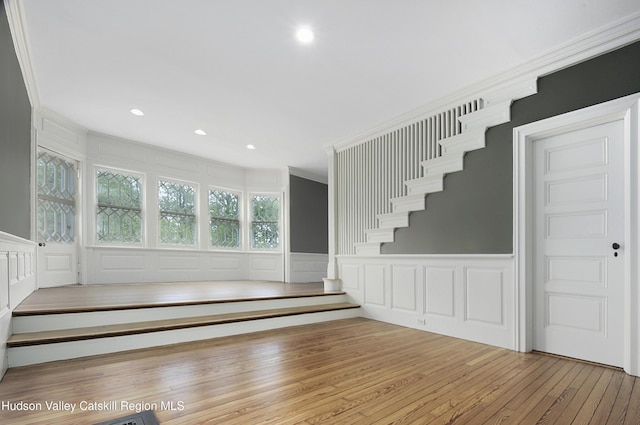 55 Leggett Rd, Stone Ridge, NY 12484 - unfurnished living room featuring a decorative wall, crown molding, stairway, hardwood / wood-style floors, and a wainscoted wall