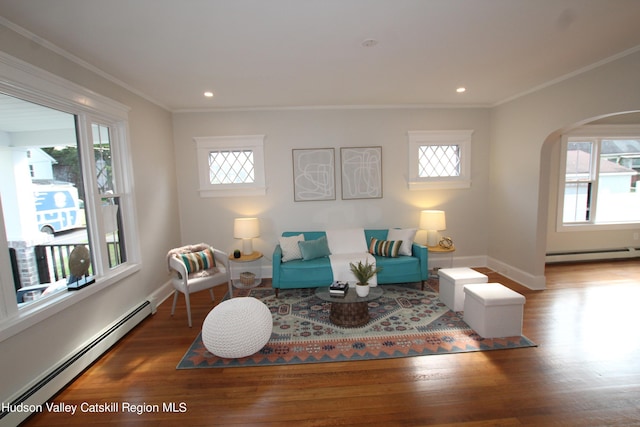 living room with hardwood / wood-style floors, a healthy amount of sunlight, and a baseboard heating unit