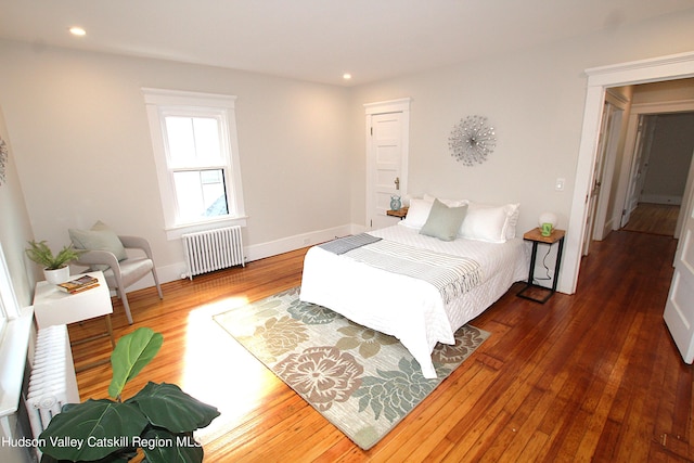 bedroom with radiator and dark hardwood / wood-style floors