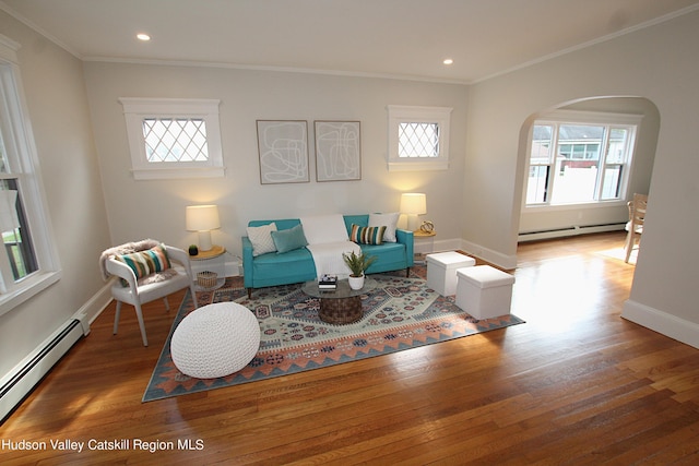 living room featuring dark hardwood / wood-style floors, ornamental molding, and a baseboard heating unit