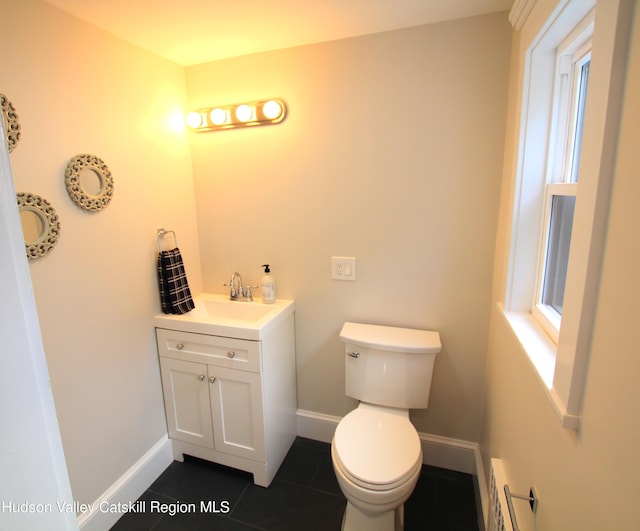 bathroom featuring tile patterned flooring, vanity, toilet, and a baseboard radiator