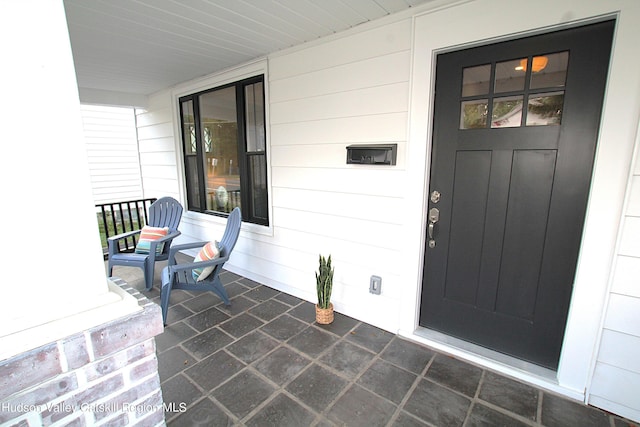 view of exterior entry with covered porch