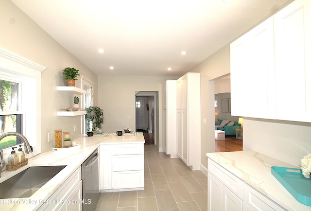 kitchen with kitchen peninsula, light stone countertops, sink, dishwasher, and white cabinetry