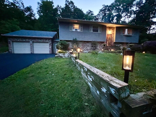 split foyer home with driveway, a front lawn, and a garage