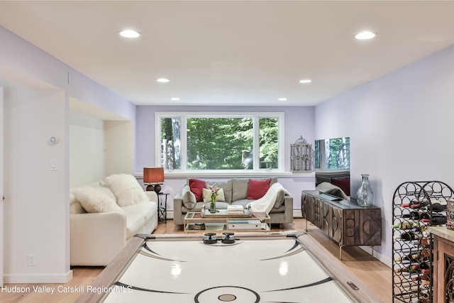 living room with baseboard heating and light hardwood / wood-style floors