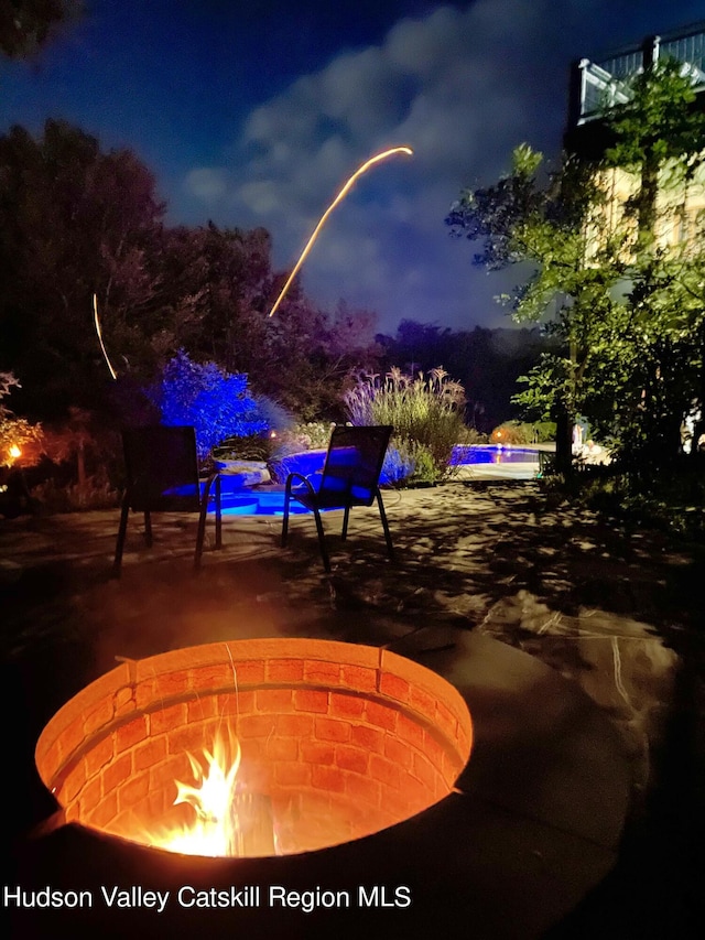 patio at twilight featuring a fire pit