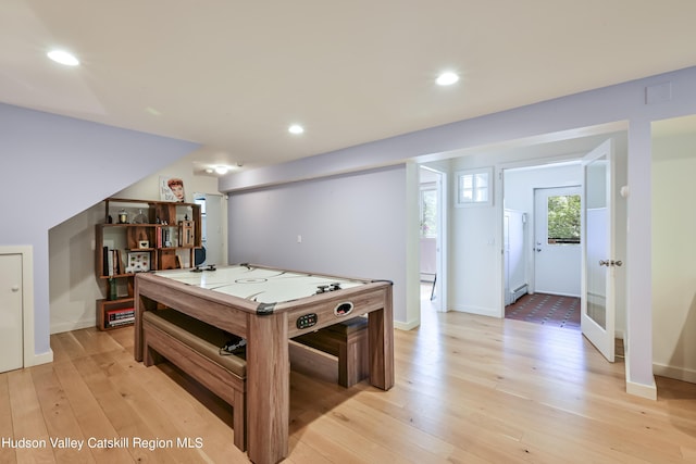 game room featuring a baseboard heating unit and light wood-type flooring