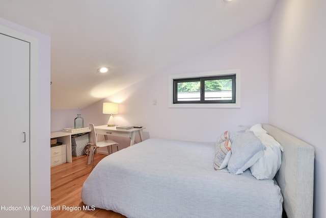 bedroom with light hardwood / wood-style floors and lofted ceiling