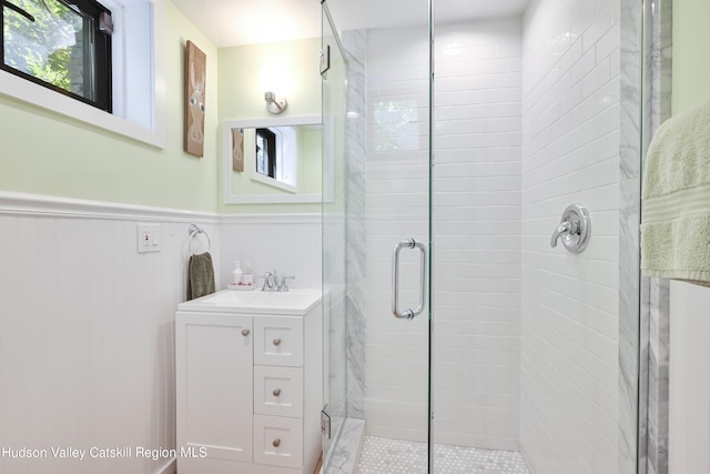 bathroom featuring vanity and a shower with door