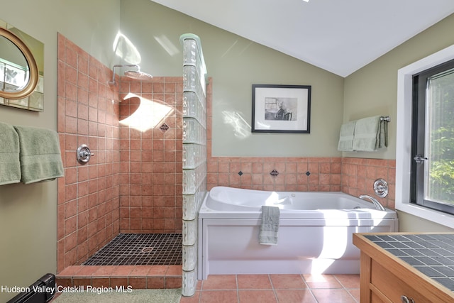 bathroom with tile patterned flooring, vanity, vaulted ceiling, and plus walk in shower