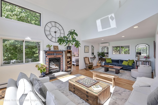 living room featuring a healthy amount of sunlight, high vaulted ceiling, and light hardwood / wood-style flooring