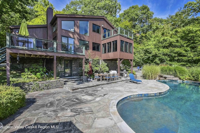 view of swimming pool featuring a grill and a patio