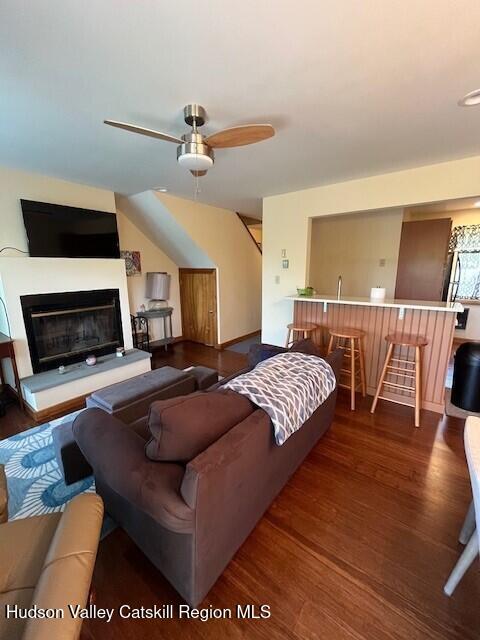 45 Windham Ridge Rd Unit 15C, Windham, NY 12496 - living room featuring wood finished floors, a ceiling fan, and a glass covered fireplace