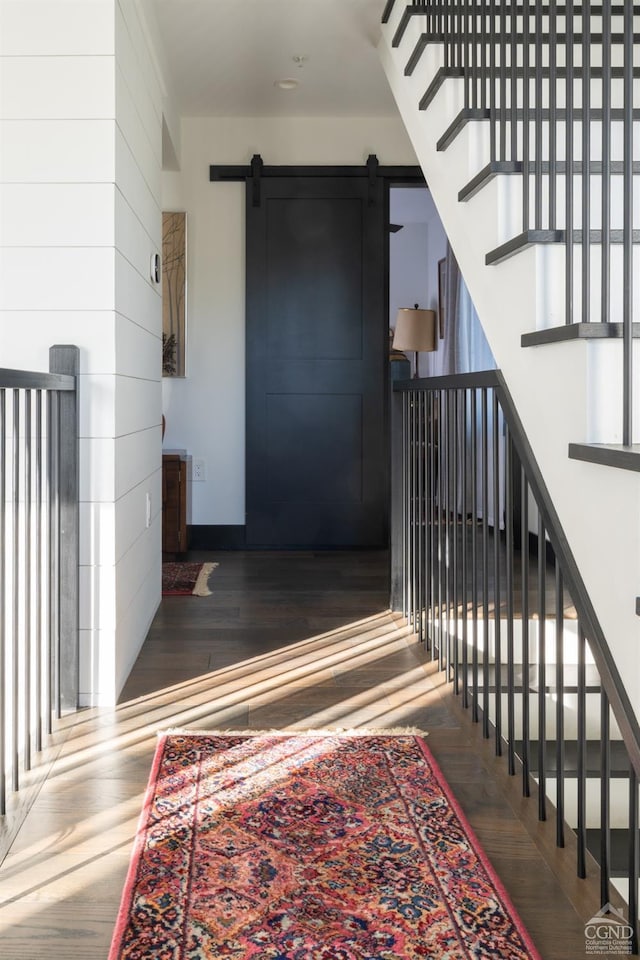 352 Columbia St, Hudson, NY 12534 - stairway featuring a barn door, wood finished floors, and baseboards